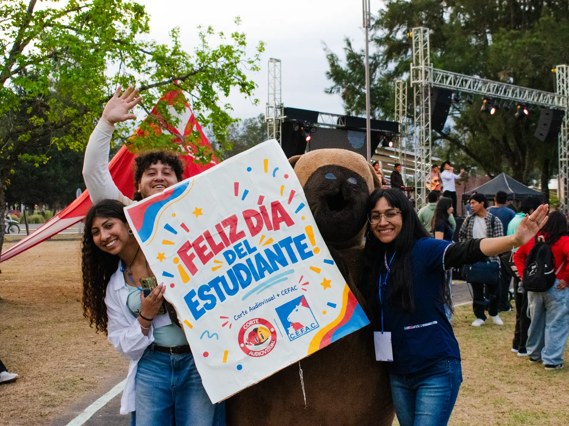 Estudiantes sostienen el cartel «Feliz Día del Estudiante» junto al carpincho del Centro.