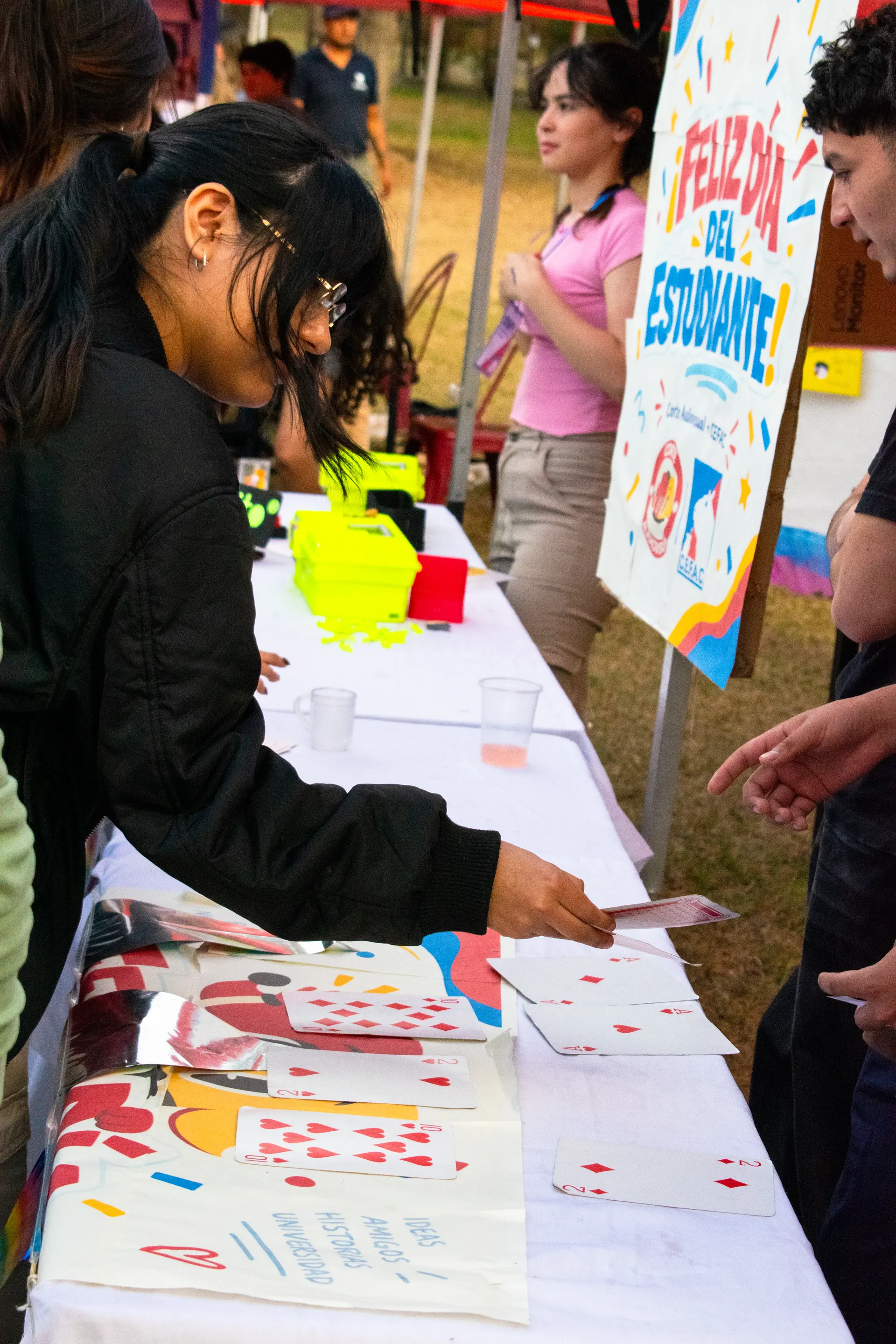 Mesa del stand del Centro con el cartel «Feliz Día del Estudiante» y estudiantes participando.